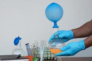 Student do science experiment, lab lesson, transparent bottles with inflated balloons on top of bottle. The experiment about air or gas reaction by using chemical substances. Education Science subject photo
