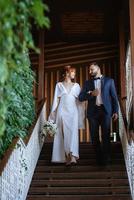 bride in a white dress with a bouquet and the groom in a blue suit photo