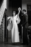 bride in a white dress with a bouquet and the groom in a blue suit photo