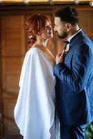 bride in a white dress with a bouquet and the groom in a blue suit photo