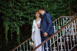 bride in a white dress with a bouquet and the groom in a blue suit photo