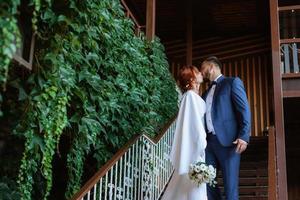 bride in a white dress with a bouquet and the groom in a blue suit photo