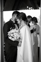 bride in a white dress with a bouquet and the groom in a blue suit photo