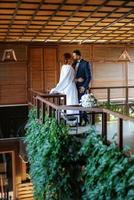 bride in a white dress with a bouquet and the groom in a blue suit photo