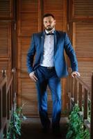 portrait of a groom with a beard in a blue suit photo