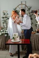 newlyweds happily cut and taste the wedding cake photo
