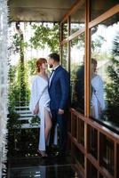 bride in a white dress with a bouquet and the groom in a blue suit photo