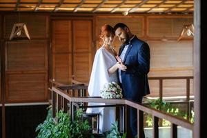 novia con un vestido blanco con un ramo y el novio con un traje azul foto