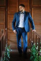 portrait of a groom with a beard in a blue suit photo