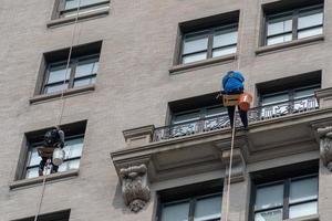 limpiadores de ventanas escalando rascacielos en nueva york foto