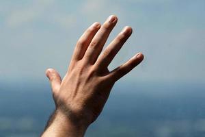 Detalle de la mano del hombre en el cristal de la ventana foto