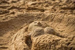 mermaid sand sculpture on the beach photo