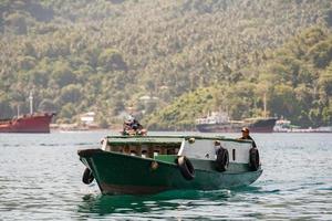 BUNAKEN, INDONESIA - APRIL, 5 2014 - fishing boat returning to fisherman village photo