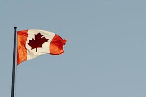 bandera canadiense bajo un cielo azul foto