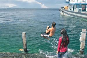 muchachos jóvenes mientras bucean en el paraíso turquesa tropical de kapalai foto