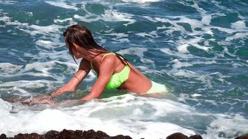 contento ragazza avendo divertimento nel ondulato mare su un' roccioso spiaggia video