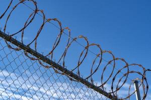 barbed wire fence on blue sky photo