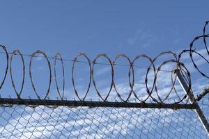 barbed wire fence on blue sky photo