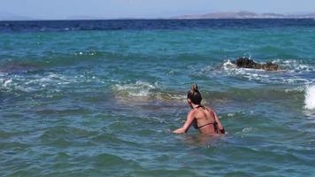 lady i randig badning kostym på de klippig havsstrand video