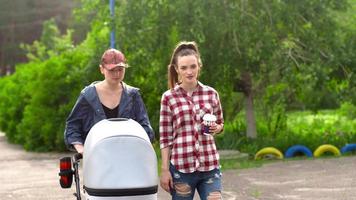 Two young girls walk with a child in a stroller video