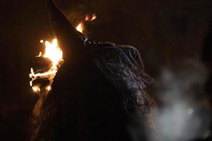 witch in the black holding a torch photo