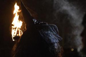 witch in the black holding a torch photo
