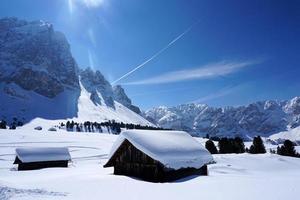 una cabaña de madera en el fondo de la nieve invernal foto