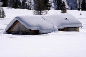 cabaña de madera en el fondo de la nieve del invierno foto