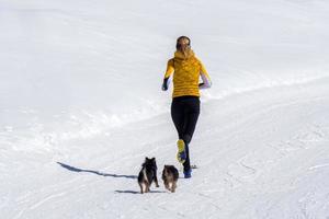 girl running with dogs on the snow photo