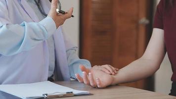 Homecare nursing service and elderly people cardiology healthcare. Close up of young hispanic female doctor nurse check mature caucasian man patient heartbeat using stethoscope during visit video