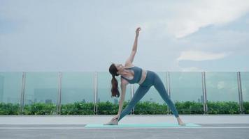 slank vrouw beoefenen yoga Aan de balkon van haar appartement. Aziatisch vrouw aan het doen opdrachten in ochtend. evenwicht, meditatie, ontspanning, kalm, mooi zo Gezondheid, Vrolijk, kom tot rust, gezond levensstijl concept video