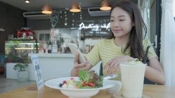 Woman use smartphone to scan QR code to pay in cafe restaurant with a digital payment without cash. Choose menu and order accumulate discount. E wallet, technology, pay online, credit card, bank app. video