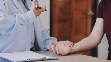 Homecare nursing service and elderly people cardiology healthcare. Close up of young hispanic female doctor nurse check mature caucasian man patient heartbeat using stethoscope during visit video