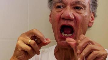 Senior man flossing his teeth with dental floss video