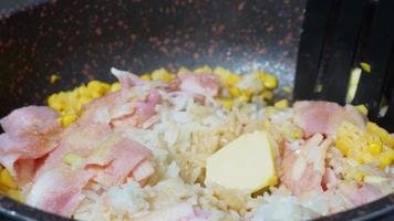 Chef frying rice with corn and bacon in pan close-up. Woman chief cooking dish with grilled vegetables, meat, Ingredients for fried rice recipe . Food and cook concept. video