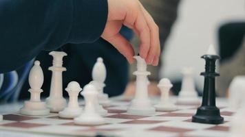 Chess game. A child's hand rearranges the chess piece to the queen by checkmating the opponent's king. video