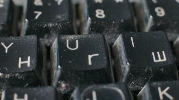 close-up de um teclado antigo em um estado dilapidado. teclado sujo com letras latinas e cirílico. video