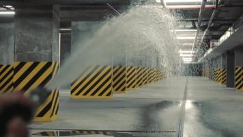 A firefighter is testing the fire safety system. Test start of water with a fire hose in the underground parking lot video