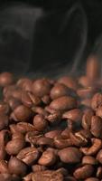 ralenti vertical de grains de café torréfiés tombant. graines de café bio. video