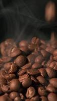 Vertical slow motion of roasted coffee beans falling. Organic coffee seeds. video