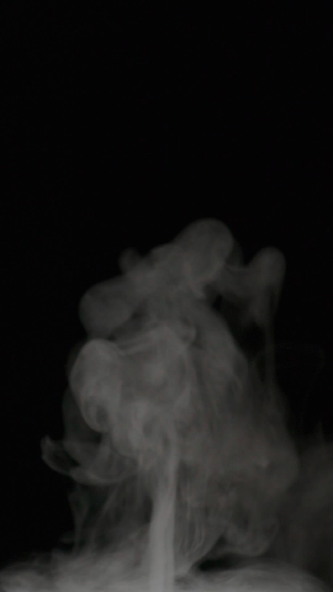 Slow motion vertical video of white smoke, fog, mist, vapor on a black ...