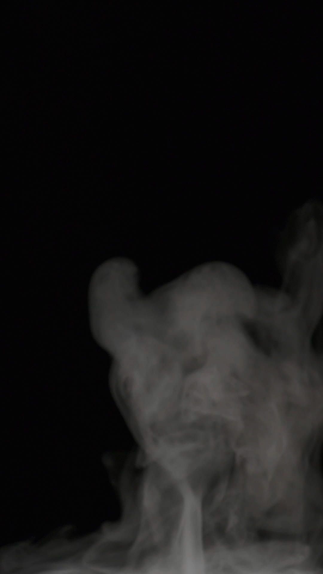 Slow motion vertical video of white smoke, fog, mist, vapor on a black ...