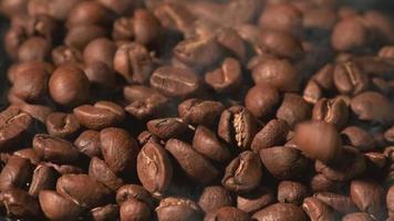 slow motion av rostade kaffebönor som faller. ekologiska kaffefrön. video