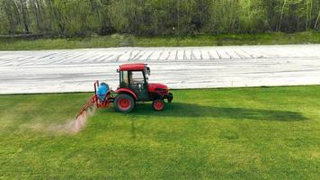 Aerial view spraying the field with water and an agrochemical solution to improve grass growth. video