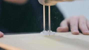 un enfant dans un cours d'artisanat cool scie un motif en contreplaqué video