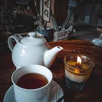 Cup of Tea and Candle on Wooden Table photo