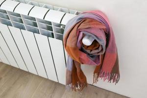 The radiator is wrapped in a multicolored warm scarf. photo
