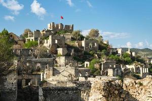 vista de la ciudad abandonada junto a kayakoy. karmilissos abandonó la ciudad fantasma en fethiye - turquía, ruinas de casas de piedra. sitio de la antigua ciudad griega foto