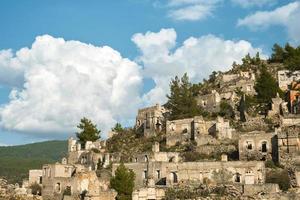 las ruinas de la ciudad griega abandonada de levissi cerca del pueblo de kayakoy en fethiye turquía, en el contexto de las nubes cúmulos, la tragedia de las guerras. sitio de la antigua ciudad de karmilissos foto