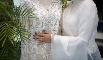 una mujer abrazando un vestido de novia blanco en un maniquí foto